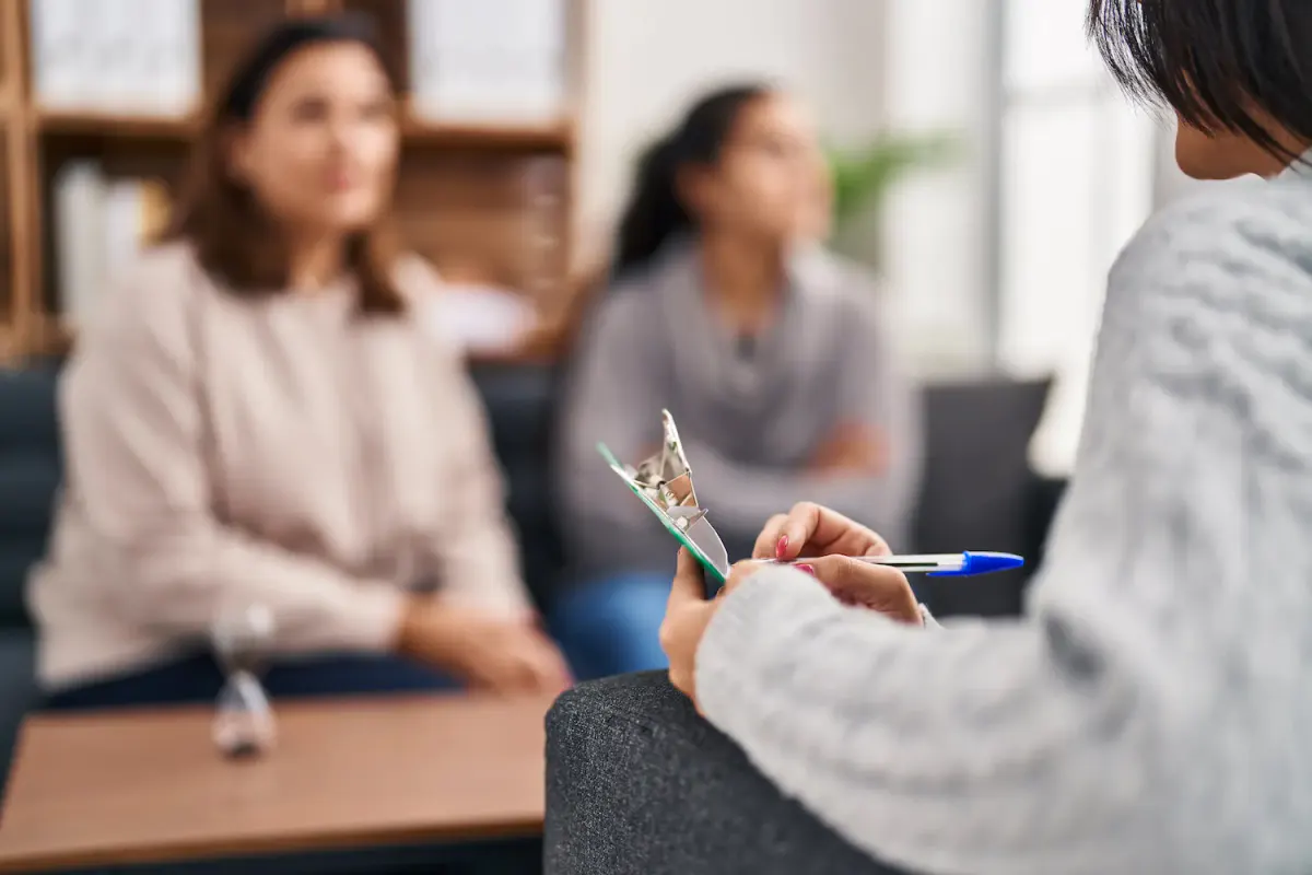 A clinician holding a clipboard and pen during a culturally informed family therapy session at More Than Rehab in Texas.